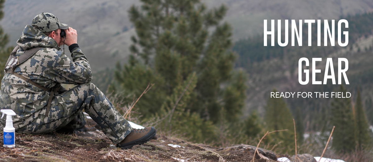A person in a camouflage hunting jacket sits on a rocky hillside outdoors, holding binoculars. Large white text on the right reads 'HUNTING GEAR' with smaller text 'READY FOR THE FIELD.